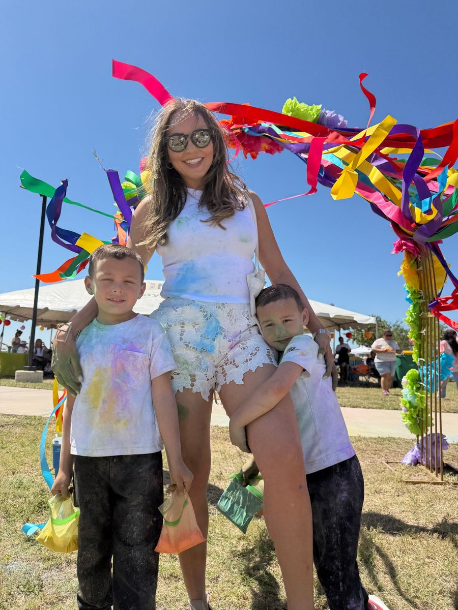 Tatiana with the boys, covered in color powder at a community festival